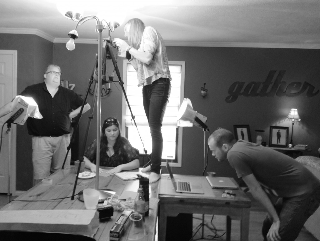 Tom (standing like normal people), Ashley (standing on a table) and Crouching Kyle film our origami artist. Please note: only one donut was harmed during filming.